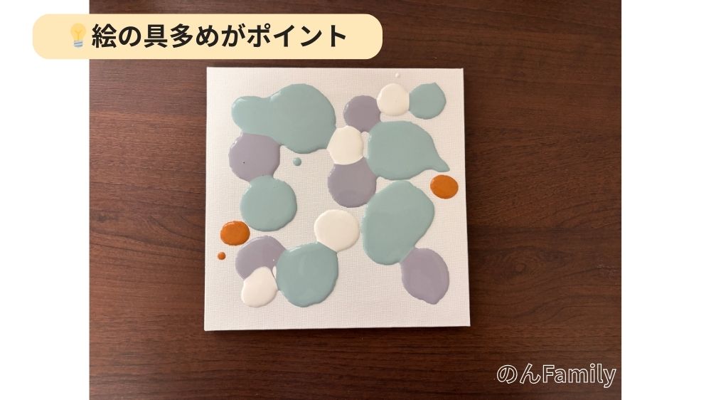 1歳誕生日のファーストアート。キャンバスにアクリル絵の具（スモーキーブルー、ラベンダー、ホワイト、オゴールド）を多めに垂らした状態。