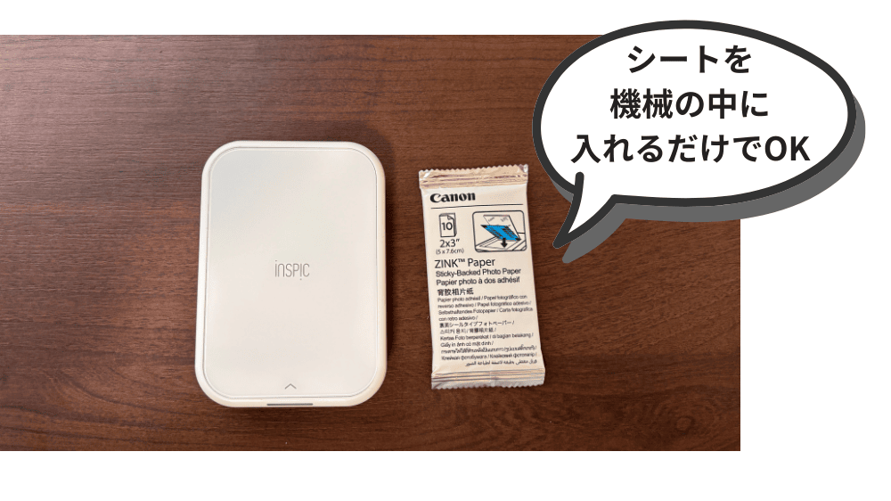 白いiNSPiC PV-223ミニプリンター本体と、キヤノン純正ZINKフォトペーパーのパッケージ。吹き出しに「シートを機械の中に入れるだけでOK」と書かれている。インク不要で専用紙を入れるだけの使い方を説明している。