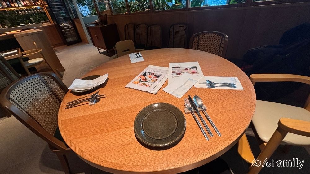 NEWoMan高輪「GARDEN HOUSE TAKANAWA」の店内テーブル席。通路が広くベビーカーのまま入店できる。温かみのある木目調の内装と、ゆったりとした席幅が特徴の子連れランチに最適な空間。
