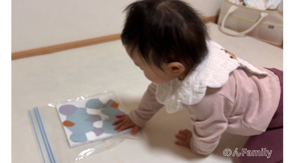 1歳児がジッパーバッグの上から指で絵の具を混ぜて、ファーストアートを作っている制作風景。