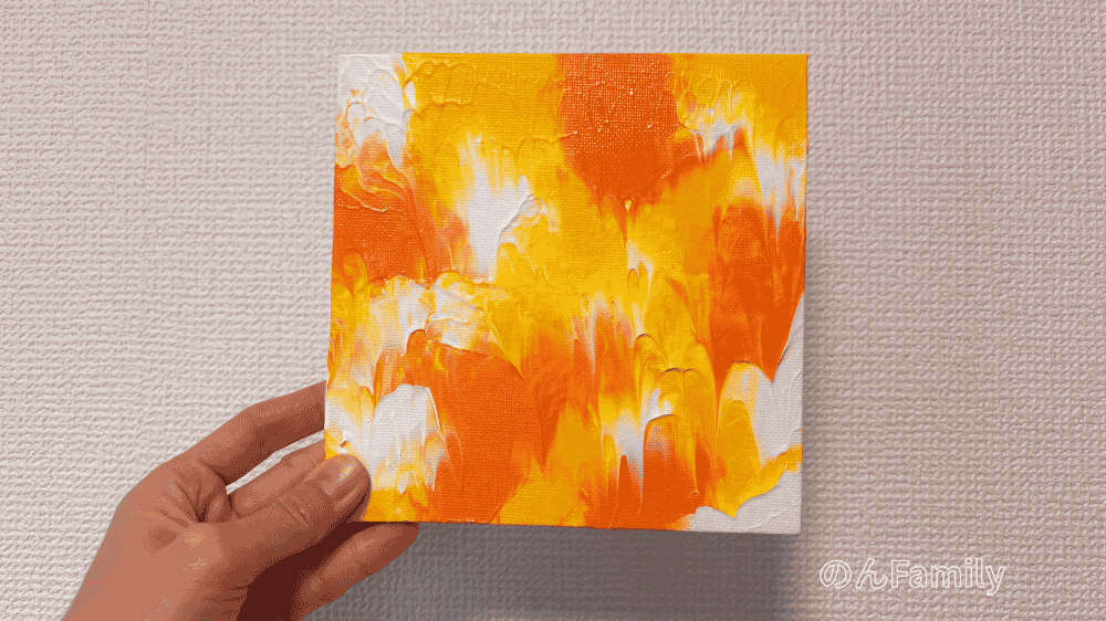 重曹なしで制作したビタミンカラーのファーストアートを手に持っている様子。絵の具本来の鮮やかな発色と平らな仕上がりが特徴。